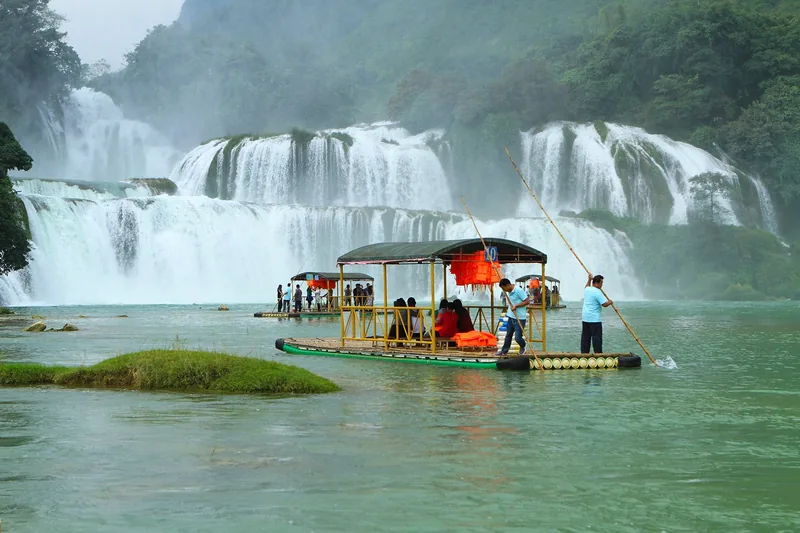 Những bè tre chở khách du lịch trên dòng nước xanh ngọc trước thác Bản Giốc hùng vĩ.