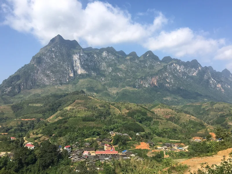 Dãy núi đá vôi hùng vĩ vươn cao trên một ngôi làng nhỏ nằm giữa những đồi xanh ở Cao Bằng, Việt Nam.