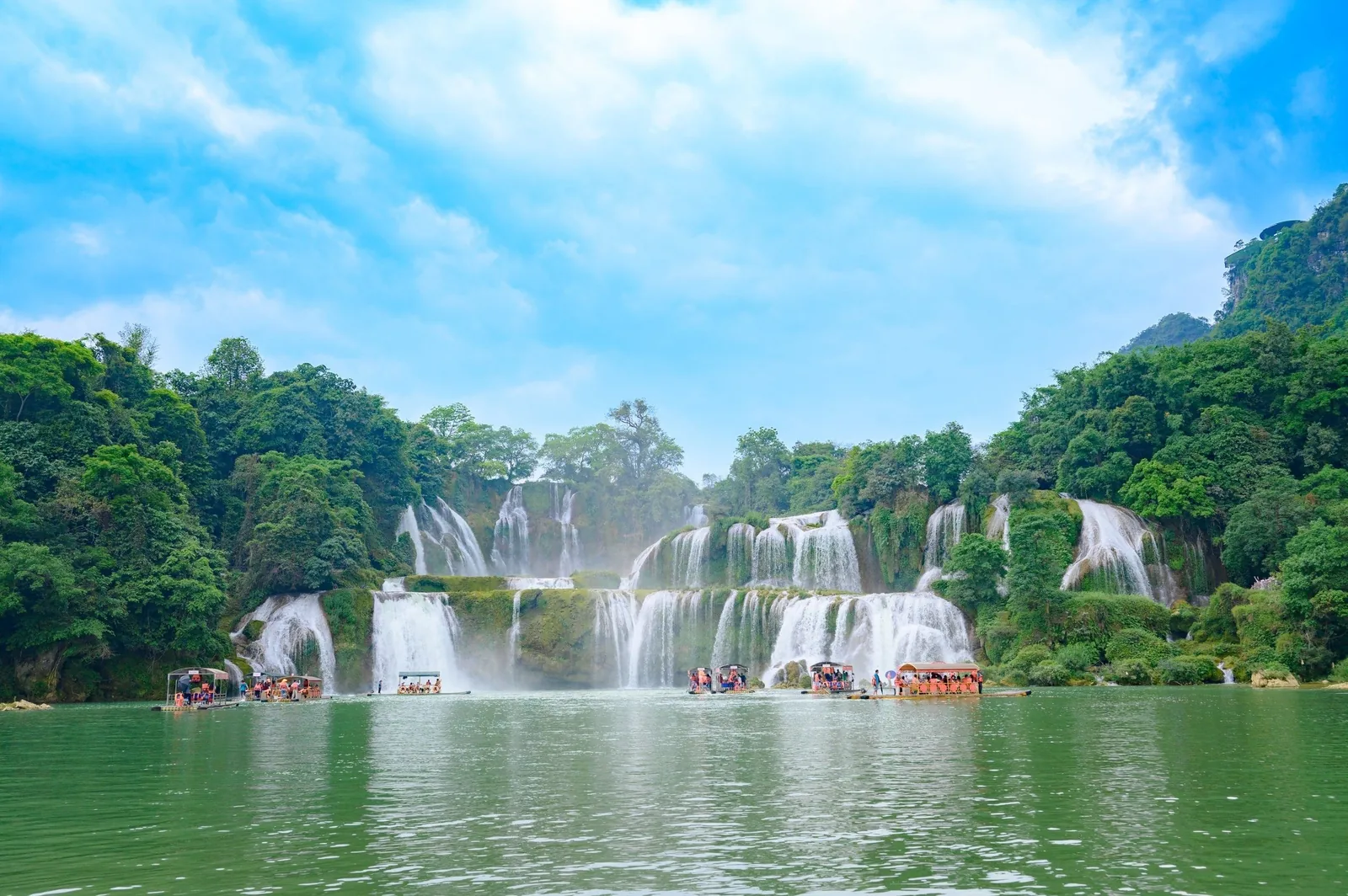 Những chiếc bè du lịch trôi trên dòng sông xanh dưới các tầng thác Bản Giốc ở Cao Bằng.